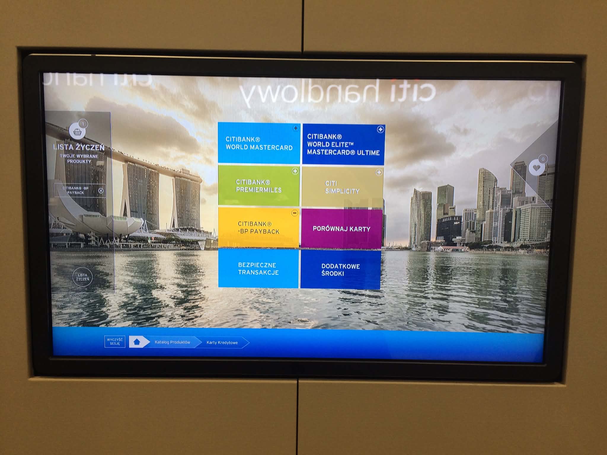 Citi Handlowy touchscreen product catalog interface photographed in a branch setting.